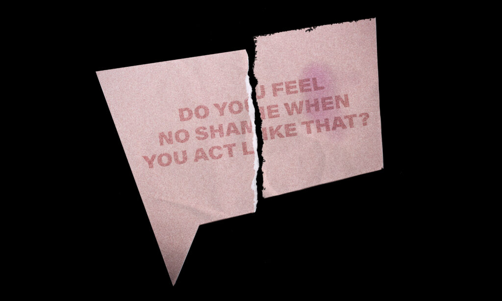 A half-torn red speech bubble paper on black background with the text "Do you feel no shame when you act like that?"