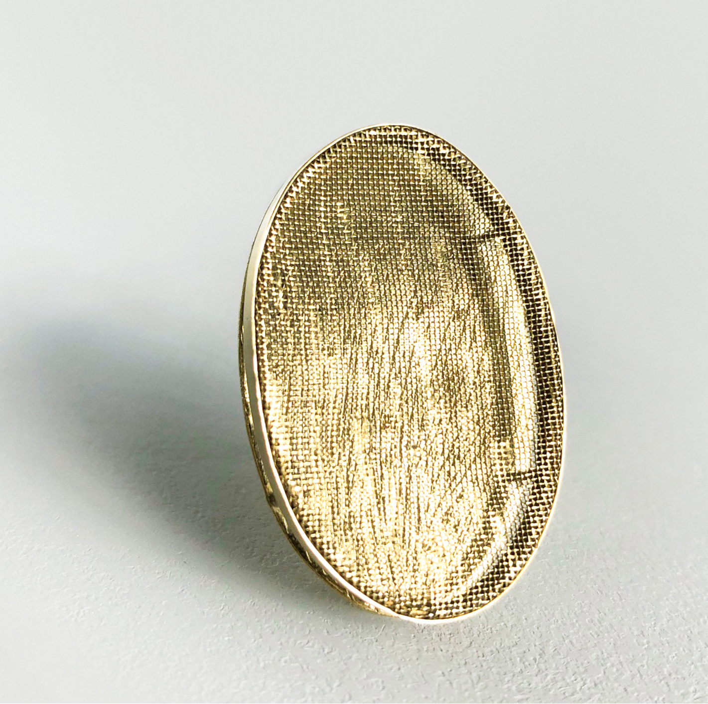 oval brass brooch on white background