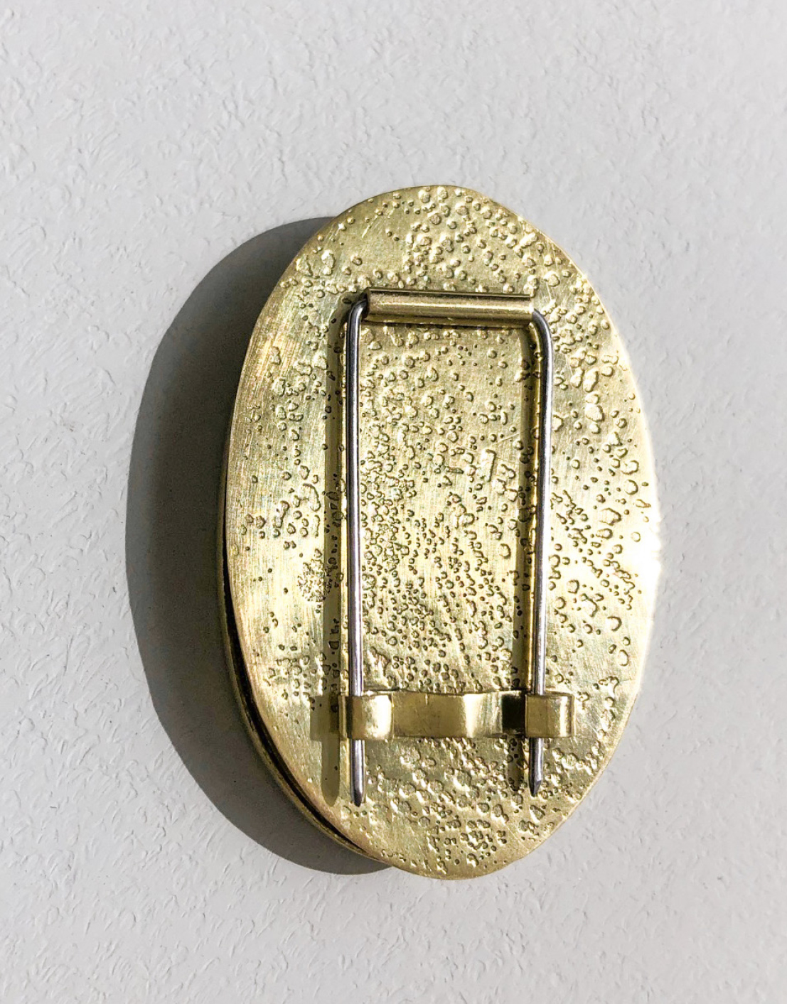 oval brass brooch on white background