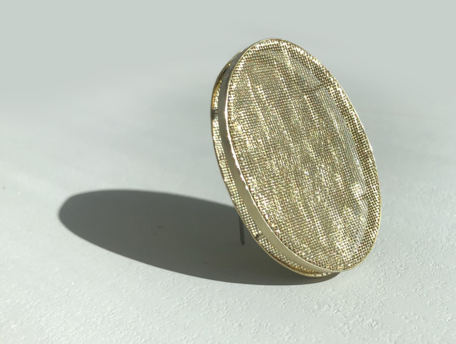 oval brass brooch on white background