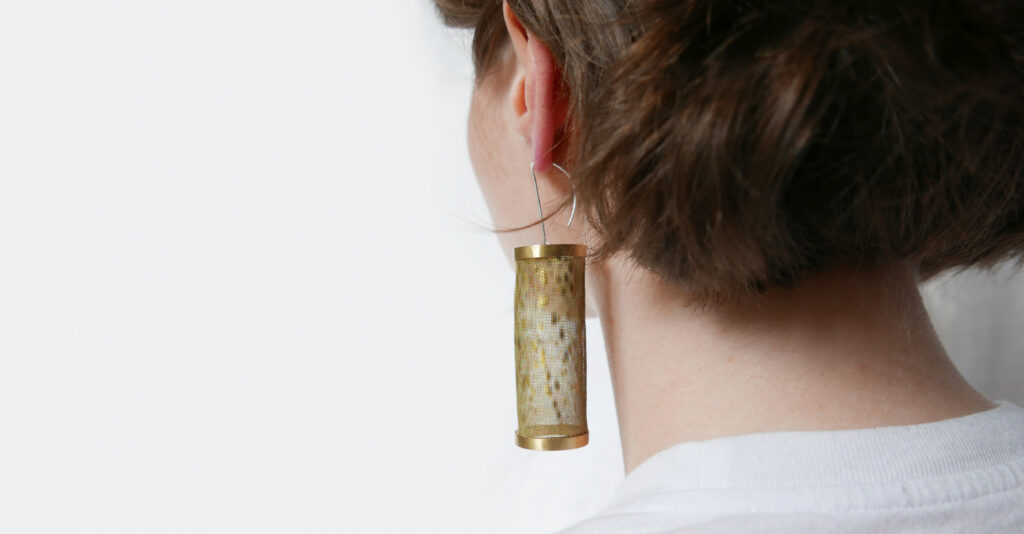 person wearing brass earrings